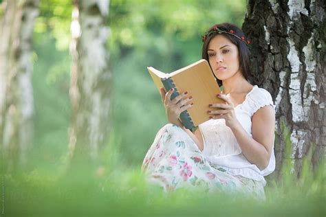 Young woman reading a book in nature. by Mosuno - Stocksy United