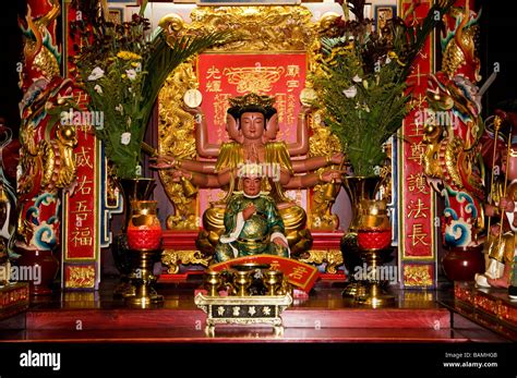 ALTAR WITH ORIENTAL GOD WITH THREE FACES SIX ARMS ORNAMENTED IN GOLD & RED Stock Photo - Alamy