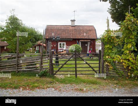 Swedish summer cottage in the countryside with a roundpole fence and a ...