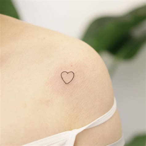 Minimalist heart tattoo on the shoulder.