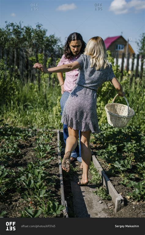 Couple walking barefoot in a garden stock photo - OFFSET