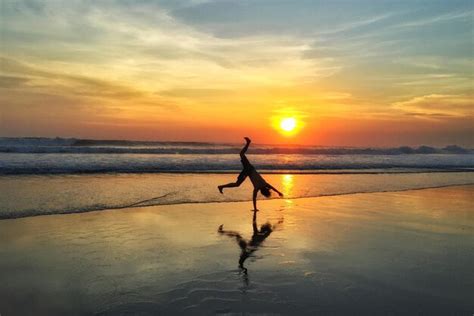 Premium Photo | Silhouette man doing cartwheel at beach against sky ...