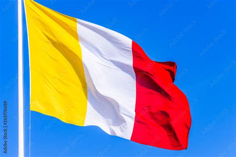 A flag with gold/yellow, white and red vertical stripes. Stock Photo ...