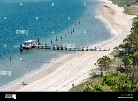 People arriving by ferry at Harkers Island, walking down dock at Cape Lookout National Seashore ...