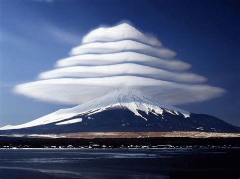 Lenticular clouds over Mount Fuji, Japan. These are stationary lens-shaped clouds that form at ...