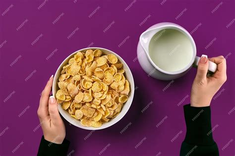 Premium Photo | Food and people concept hands of woman eating cereals corn flakes for breakfast ...