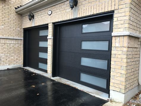 Jet black steel garage doors have an impressive design with color and vertical window pattern ...