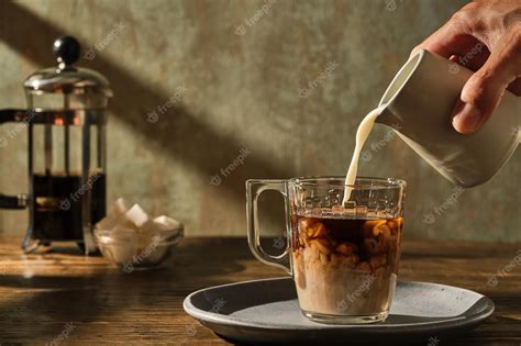 Premium Photo | Pouring milk into the coffee