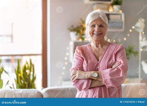 Confident Senior Woman Leaning On Bicycle In Park With Yellow Lens Flare In Background Royalty ...