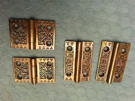 four antique brass door handles on a blue carpet