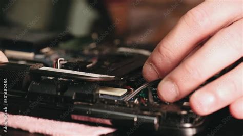 Laptop cooling system repair disconnecting the cable and removing the cooling cooler, close-up ...