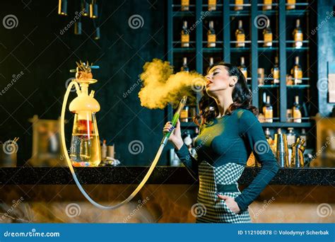 Young Woman Smoking A Hookah Behind The Bar. Cloud Of Smoke. Beauty Portrait Of Young Woman ...