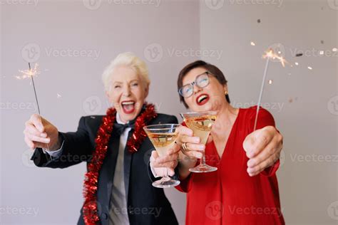 Two beautiful stylish mature senior women celebrating new year. Fun ...