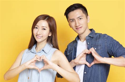 Young Couple with Heart Shape Hand Sign Stock Image - Image of happiness, romance: 148378343