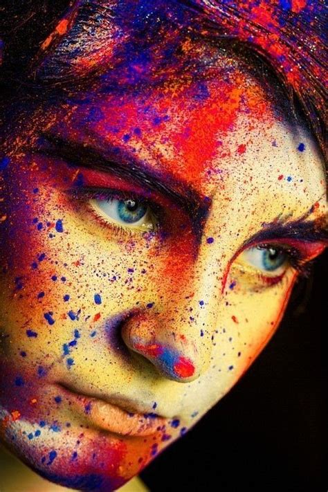 a woman's face is covered in multicolored paint