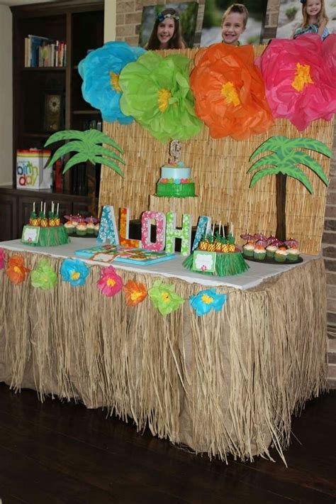 an image of a birthday party with decorations on the table and palm trees in the background