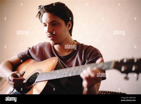 Young man singing while playing guitar at home Stock Photo - Alamy