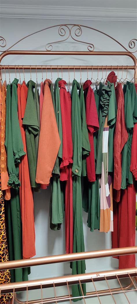 a rack with many different colored clothes hanging from it's sides and on top of each other