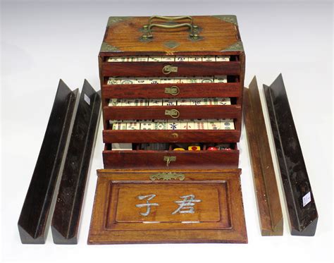 A Chinese Mahjong set, mid-20th century, with bone and bamboo tiles, within a brass mounted hardwood