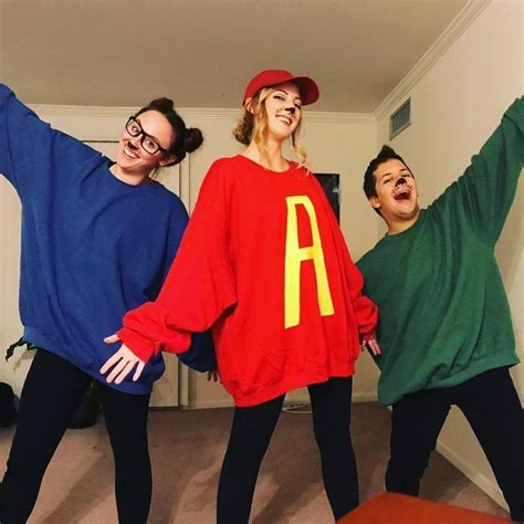 three people in matching sweaters posing for the camera