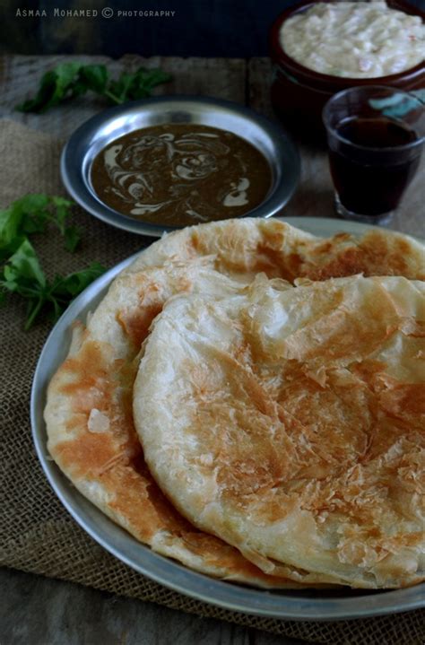 two pita breads sitting on top of a plate next to some dipping sauce