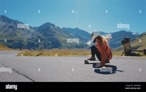 Cinematic downhill longboard session. Young woman skateboarding and ...