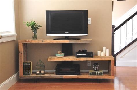 a flat screen tv sitting on top of a wooden shelf next to a stair case