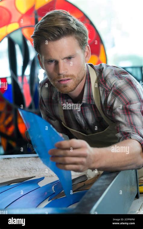 stained glass artisan picking up blue glass Stock Photo - Alamy