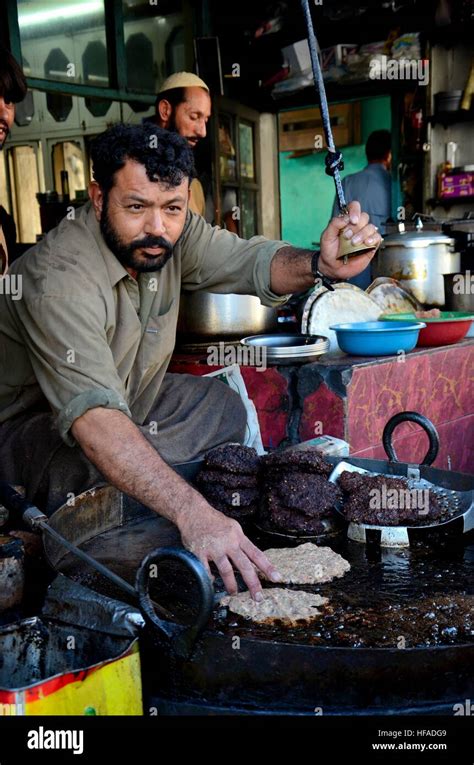 Man prepares Pakistani chapli kebab meat dish on skillet Gilgit ...