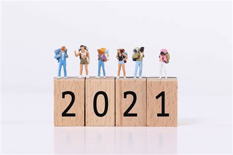 Miniature travelers standing on wooden blocks with 2021 text - Creative Commons Bilder