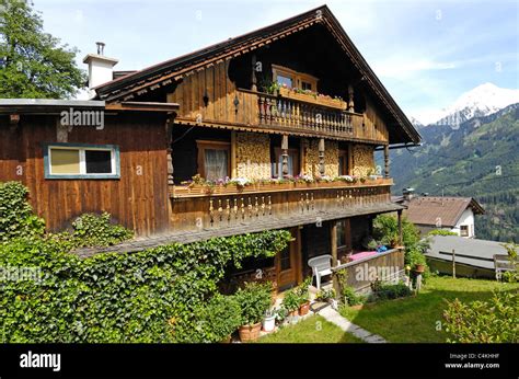 Traditional Austrian wooden house with balconies and coloured flower ...