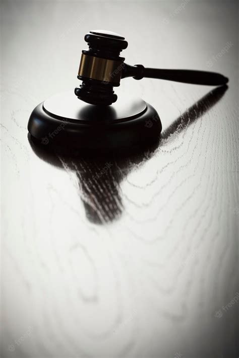 Premium Photo | Dramatic gavel silhouette on reflective wood