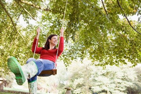 Young woman on garden swing | Stock Photo | Colourbox | Tree swing, Backyard trees, Garden swing