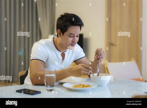 An Asian man is eating dinner alone at the dining table at night at home Stock Photo - Alamy