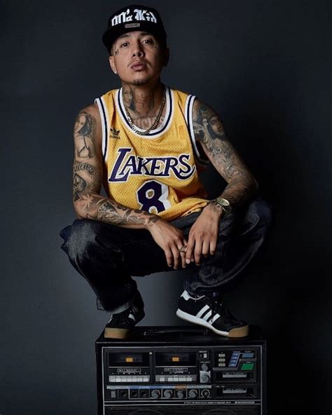 a man with tattoos sitting on top of a radio