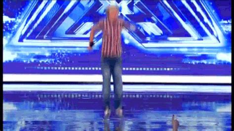 a man standing on top of a blue stage