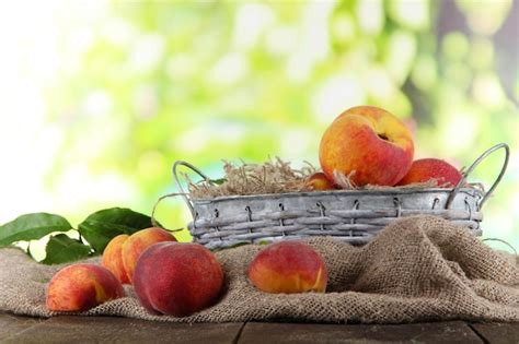 Premium Photo | Peaches in basket on sackcloth on wooden table on nature background