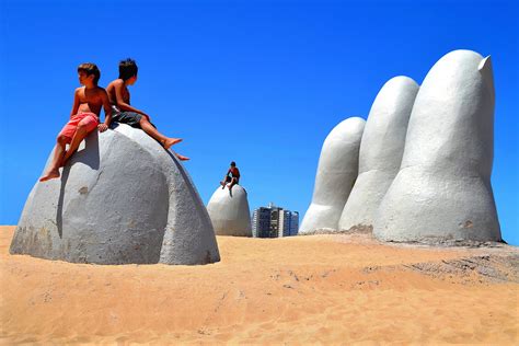 Boys Sitting on La Mano, The Hand, on Brava Beach in Punta del Este ...