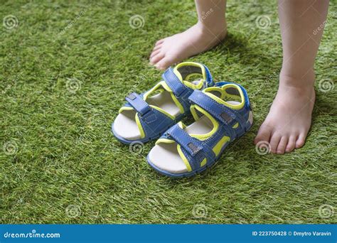 Little Boy Legs Barefoot and Sandals on the Green Artificial Grass ...