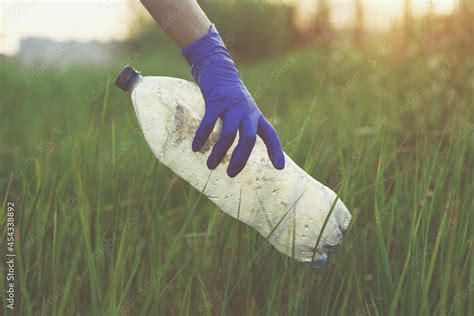 Volunteer young woman hand collecting trash outside, picking up plastic ...