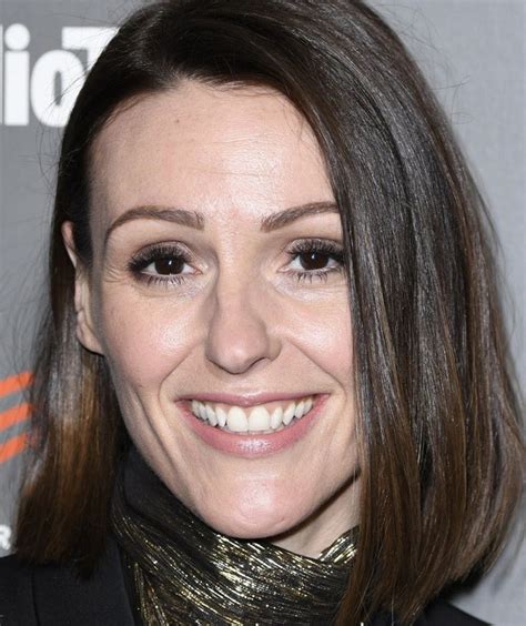 a close up of a person wearing a black suit and gold neck scarf smiling ...