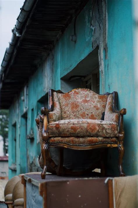 Abandoned Furniture and Armchair near Building Wall · Free Stock Photo