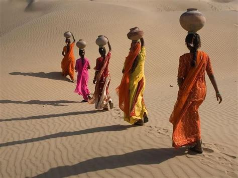 Women carrying water on their heads from the nearest well to their village in Rajasthan, India ...