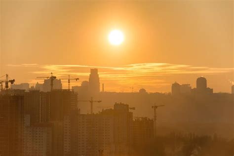 Premium Photo | Panoramic view of sunset in the city with silhouette of buildings and industrial ...