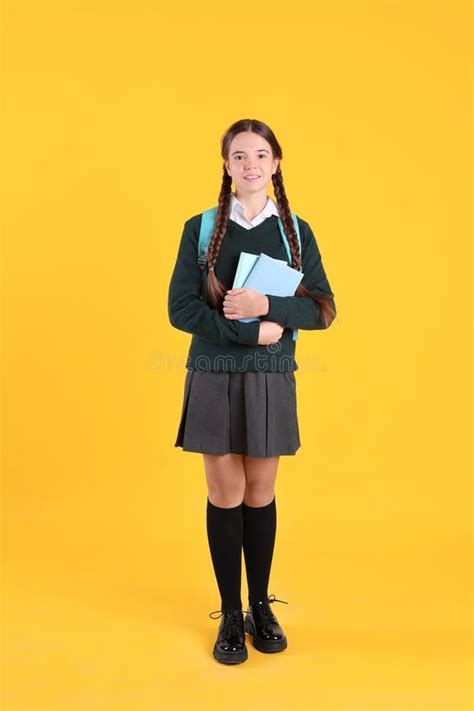 Teenage Girl in School Uniform with Books and Backpack on Yellow ...