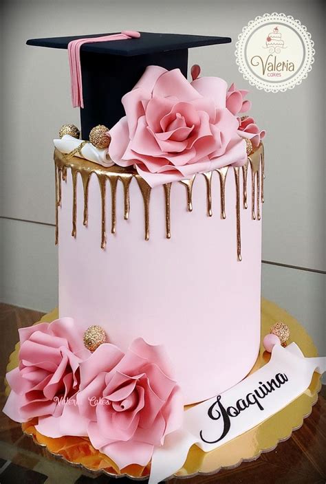 a pink and gold graduation cake with chocolate drips on the top is decorated with flowers
