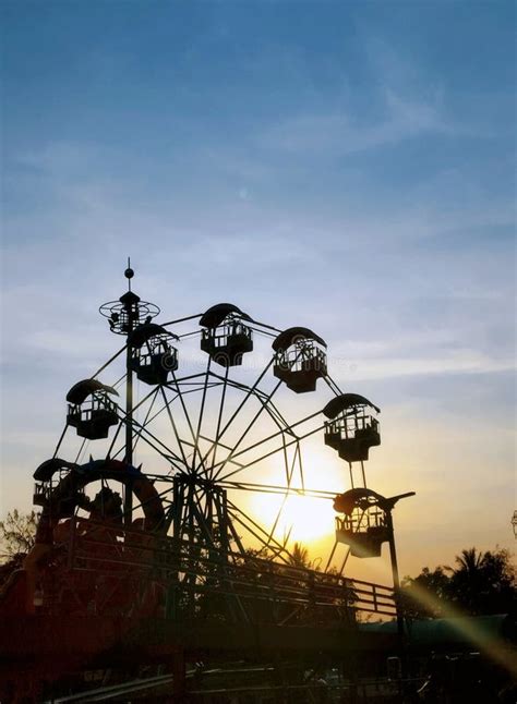 Silhouette of Ferris Wheel at Sunrise, Ferris Wheel Sunset with Cloudy Sky between Trees and ...