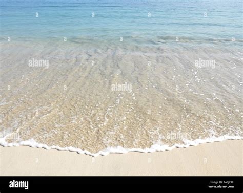 Wave and ripples on a sandy beach Stock Photo - Alamy