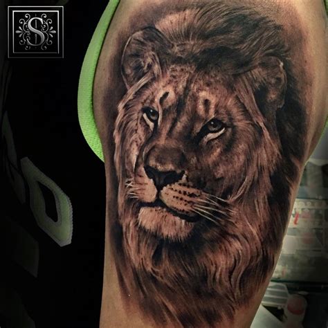 Black and grey style lion tattoo on the left forearm.