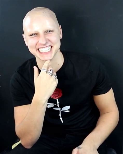 a man sitting down with his finger in his mouth and wearing a rose ring on his left hand